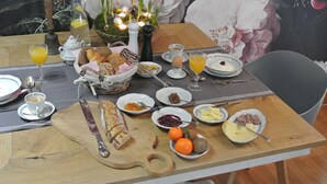 Une table de petit-déjeuner avec divers aliments, une carafe et une bougie.