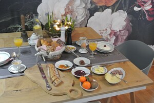 Una mesa de desayuno con diferentes alimentos, una jarra y una vela.