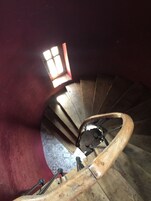 Una escalera de caracol con escalones de madera y barandilla de metal.