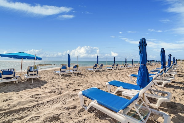 On the beach, white sand, beach cabanas, sun loungers