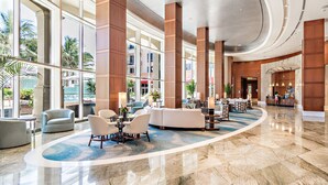 A spacious lobby with a marble floor, large windows, and a reception desk. - Palm Beach Singer Island Beach Resort Condos (Singer Island)