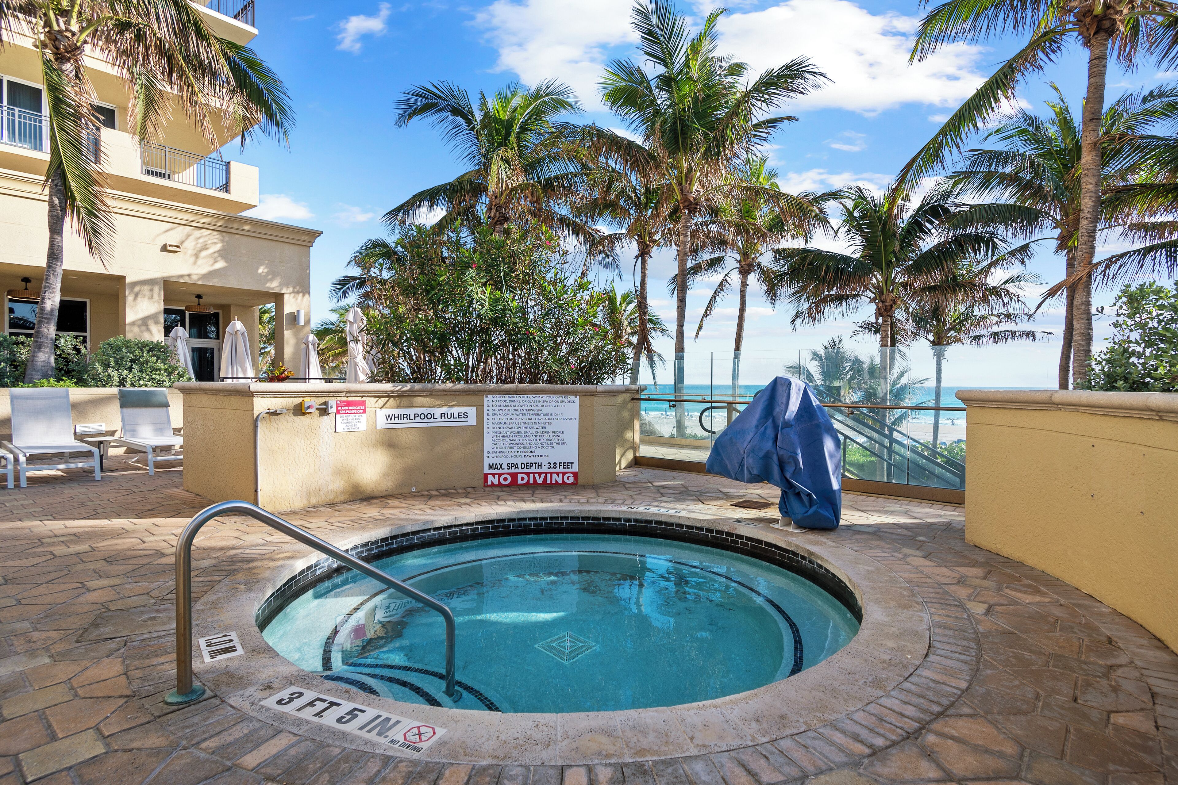 A pool area with a sign indicating a maximum depth of 3 feet and a no diving rule.