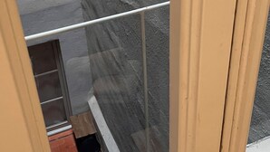 A window with a view of a tiled floor and a door. - Hostal Argo (Barcelona)