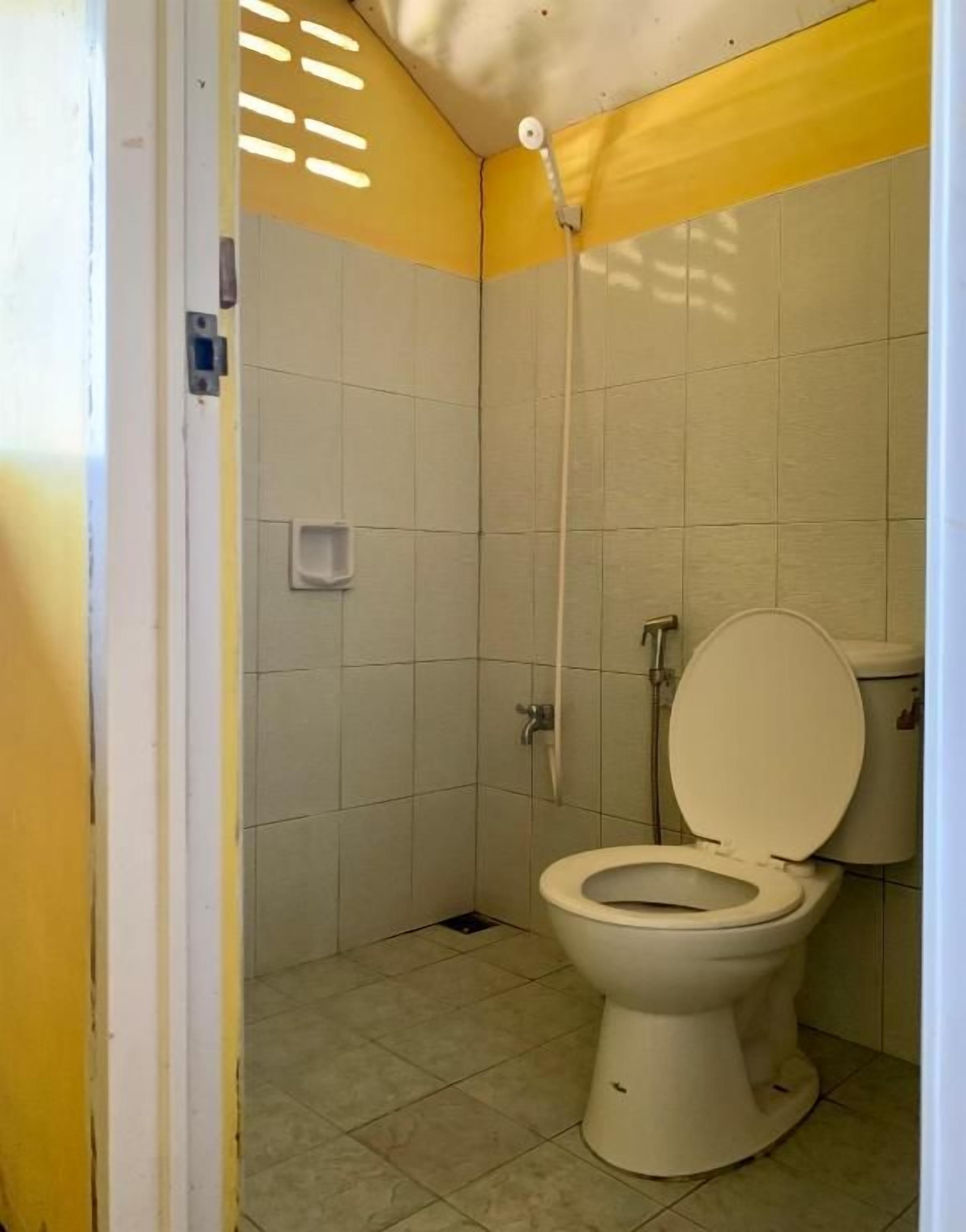 A small bathroom with a toilet, a shower, and a sink.
