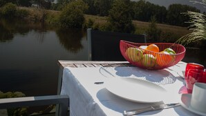Taula amb estovell blanc, un bol de fruita vermella i una tassa vermella.