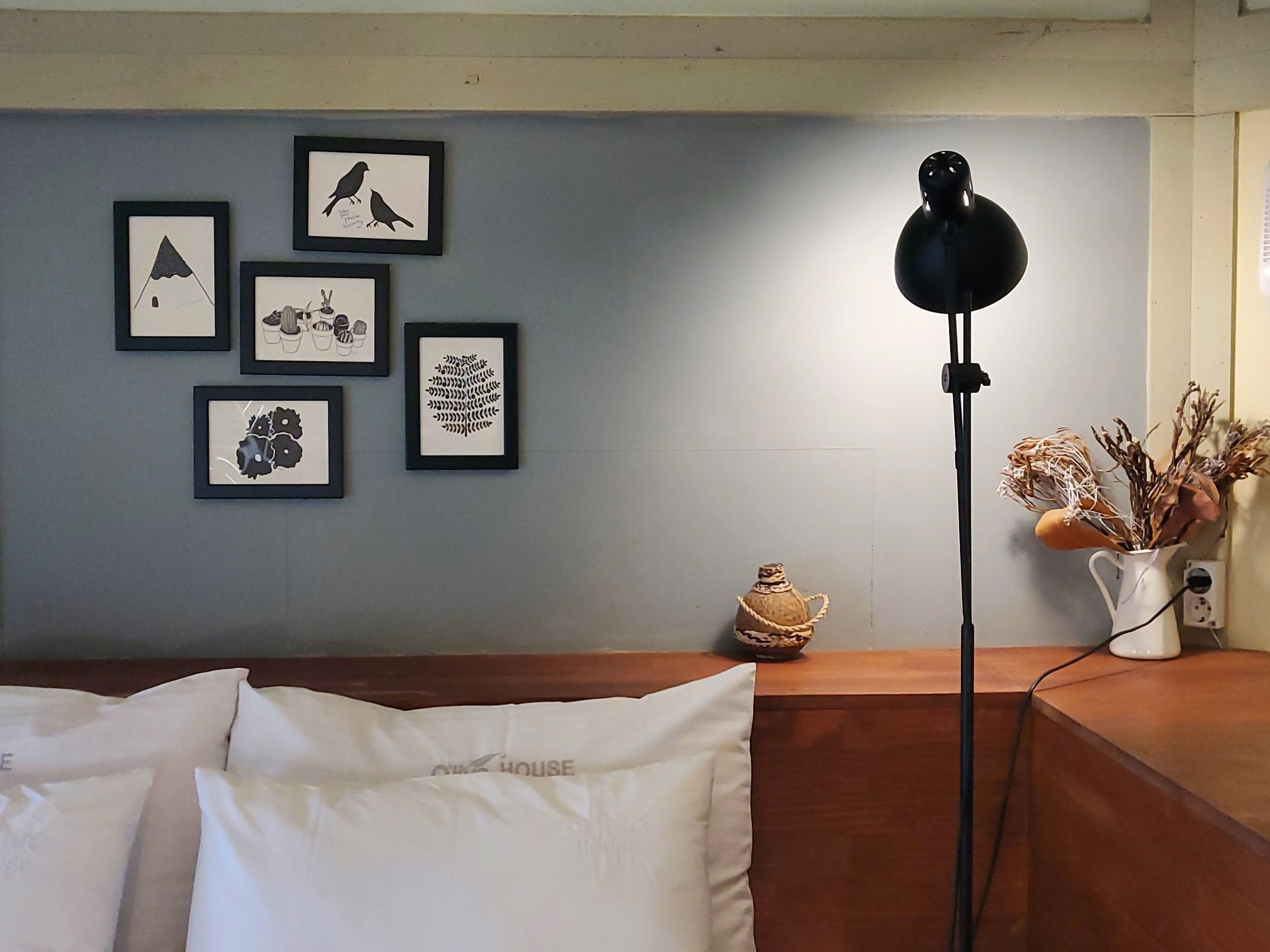 Una habitación con cama, lámpara y decoración en la pared.