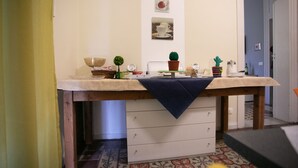 A kitchen with a wooden table, white cabinets, and a tiled floor. - Belle Epoque B&B (Trapani)