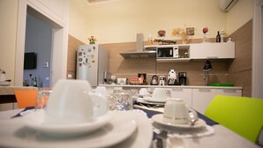 A modern kitchen with white cabinets, a microwave, and a coffee maker. - Belle Epoque B&B (Trapani)