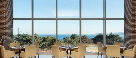 A dining area with a large window overlooking a scenic landscape.