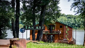 Une cabane en bois avec une enseigne indiquant « SAN ART HOSTEL » et une antenne parabolique.