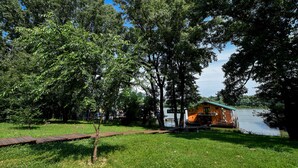 Une cabane en bois au bord d’un lac, avec un quai, entourée d’arbres.