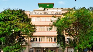 Un hôtel appelé «Hotel Harbour View», avec une enseigne, de nombreuses fenêtres et un auvent vert.