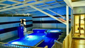 A large indoor swimming pool with multiple hot tubs and a water slide. - Hotel El Giro (Villa de Leyva)