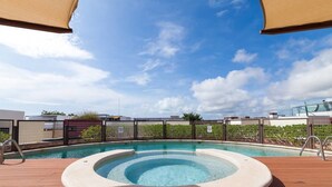 A rooftop swimming pool with a clear blue sky and a wooden deck. - Heliko 102 by CocoBR (Playa del Carmen)