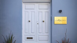 A white door with a gold plaque reading "LEMONTREE" and two potted plants on either side. - Lemon Tree Relais by CX Collection (Zabbar)