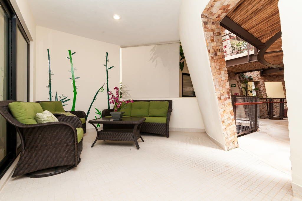 Ein geräumiger Balkon mit Korbmöbeln, einem kleinen Tisch und einem Blumentopf.