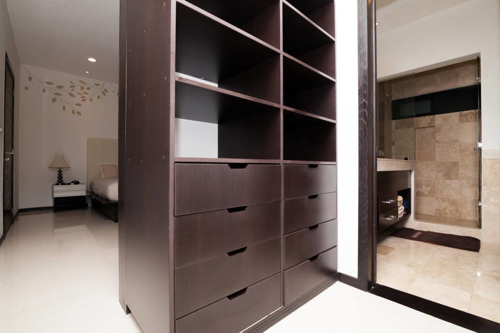 A modern bedroom with a built-in wardrobe, a bedside table, and a nightstand.