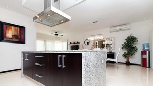 A modern kitchen with dark cabinets, a granite countertop, and a central island. - Heliko 201 by cocoBR (Playa del Carmen)