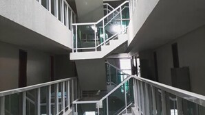 A multi-level interior with glass railings and white walls. - Oriental Praia Hotel (João Pessoa)