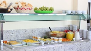 A buffet setup with various food items including fruits, vegetables, and prepared dishes. - Oriental Praia Hotel (João Pessoa)