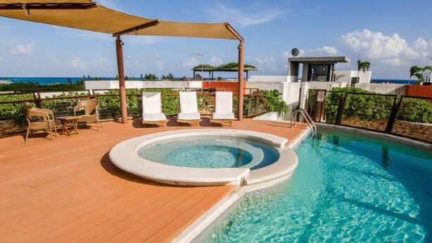 A rooftop pool with a hot tub, lounge chairs, and a view of the ocean. - Heliko 305 by CocoBR (Playa del Carmen)