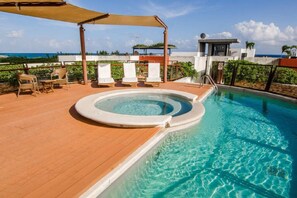 A rooftop pool with a hot tub, lounge chairs, and a view of the ocean. - Heliko 305 by CocoBR (Playa del Carmen)