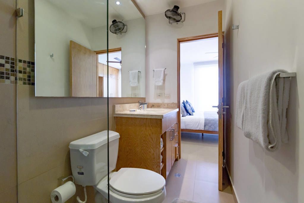 Une salle de bain avec des toilettes, un lavabo et un miroir.
