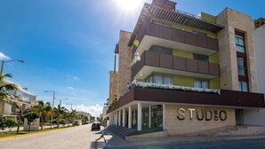 A modern building with a sign reading "STUDIO" on the facade, featuring a multi-story structure with balconies and a flat roof. - Studio one 208 by CocoBR (Playa del Carmen)
