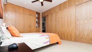 A bedroom with a bed, wooden wardrobe, and a ceiling fan. - Studio one 303 by CocoBR (Playa del Carmen)