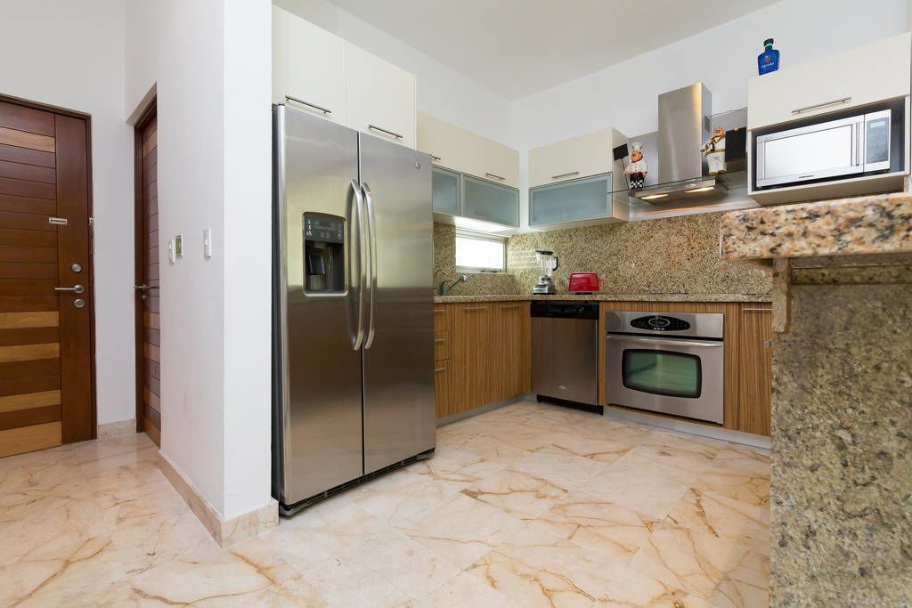 A modern kitchen with stainless steel appliances, wooden cabinets, and granite countertops.