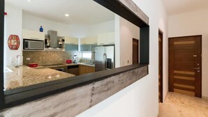 A modern kitchen with granite countertops, stainless steel appliances, and a wooden accent wall.