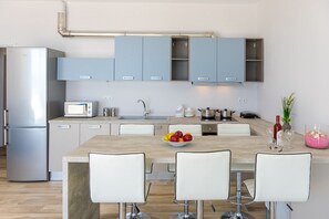 Enjoy cooking and dining in this well-equipped kitchen with a central island, sink, and various appliances.