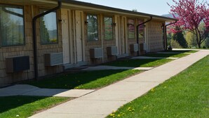 A row of single-story buildings with large windows and air conditioning units.