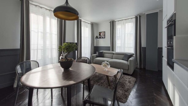 A modern living room with a dining table, sofa, and a large window. - Black Pearl, 1BR/1BA, 3 people (París)