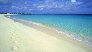 Una playa con aguas turquesas cristalinas y una orilla arenosa.