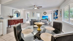 A dining area with a round glass table, black chairs, and a decorative bowl. - Awesome Location! ☀Unlimited Sunsets Included☀ (Indian Rocks Beach)