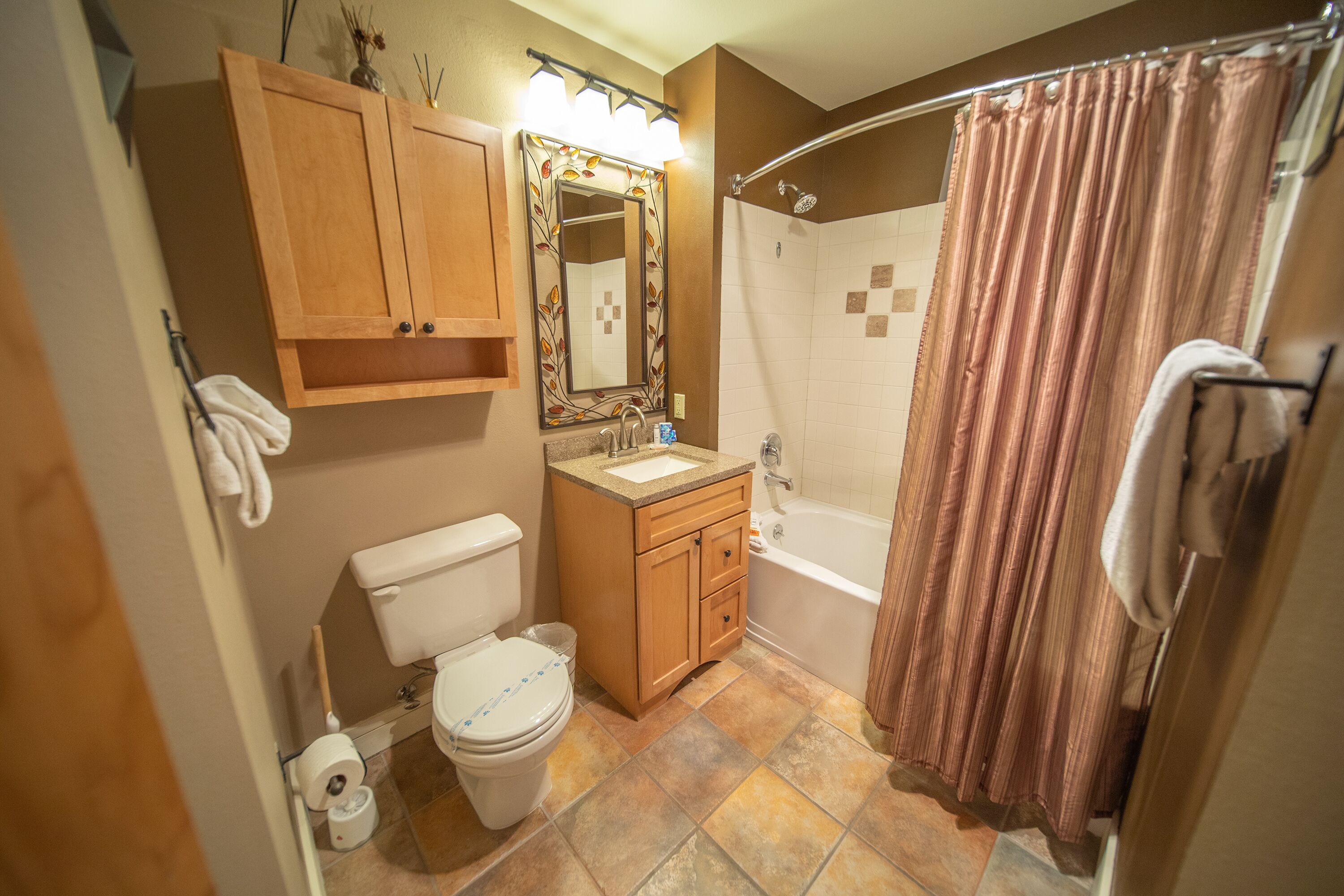 Un bagno con servizi igienici, lavandino, mobile lavabo e doccia.