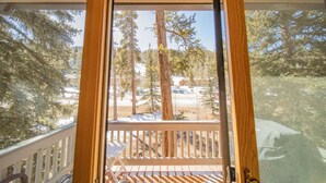 A wooden deck with a white railing, overlooking a snowy landscape with trees and a clear sky. - Ironwood 2986 by SummitCove Vacation Lodging (Keystone)