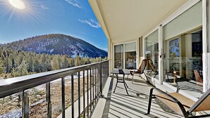 A balcony with a view of a forested mountain range. - Pines 2086 (Keystone)