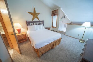 A bedroom with a bed, nightstands, a star decoration, a window, and a lamp. - Ski Run 302 (Keystone)