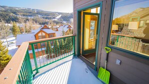 A balcony with a view of a snowy landscape and houses. - Gateway Lodge 5089 (Keystone)