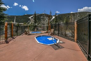 Relax by the serene pools surrounded by lush trees and distant mountains.