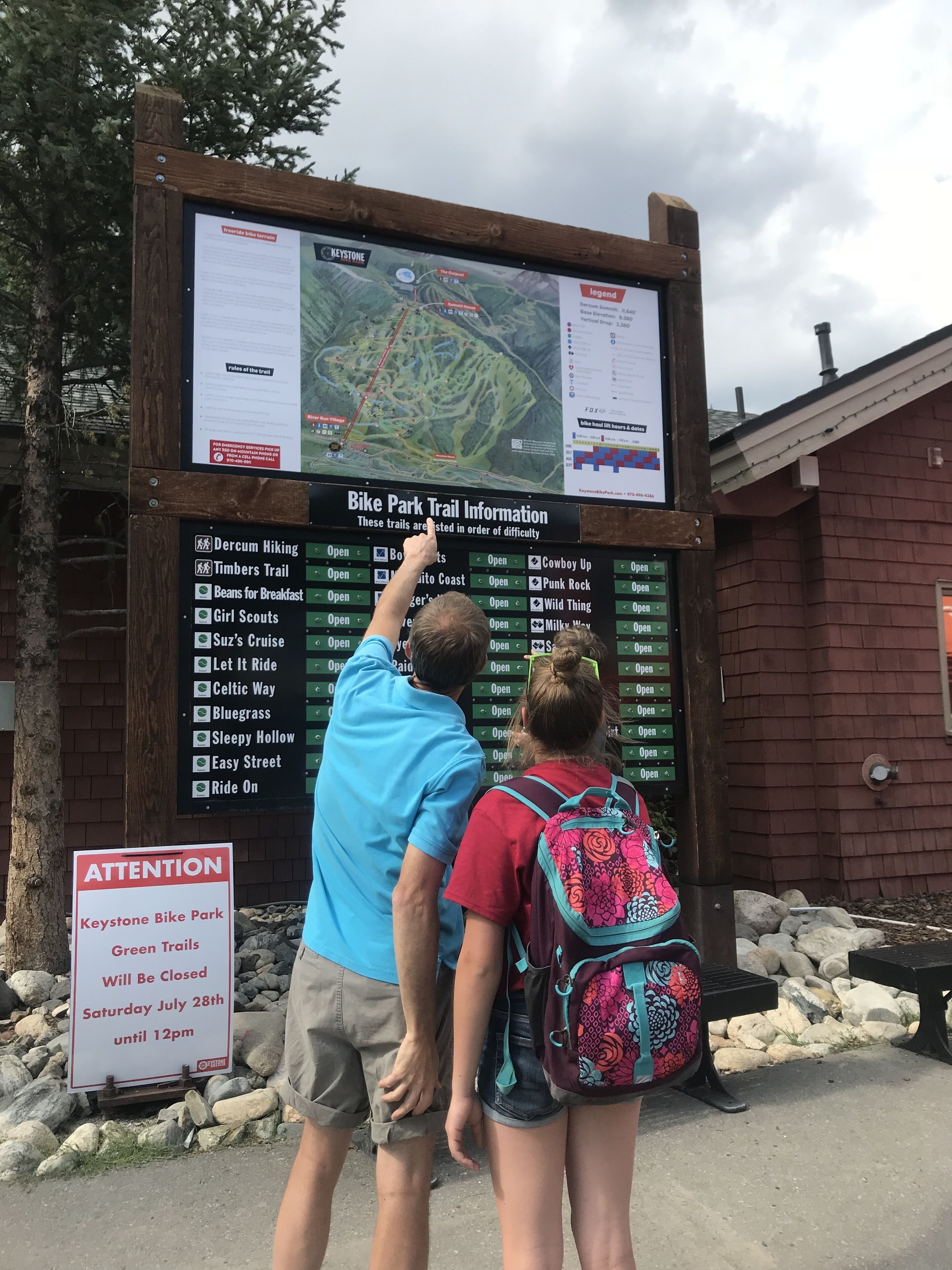 A wooden signboard with trail information for Keystone Bike Park.