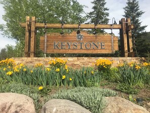 Experience the charm of Keystone, where a welcoming garden and rustic sign set the tone for a warm atmosphere.