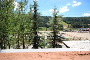 A view of a parking area with vehicles, surrounded by trees and a mountainous landscape in the background. - Springs 8846 (Keystone)