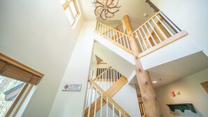 A multi-level wooden staircase with a unique chandelier, a sign indicating a medical facility, and a view of the outdoors. - Starfire 1979 (Keystone)
