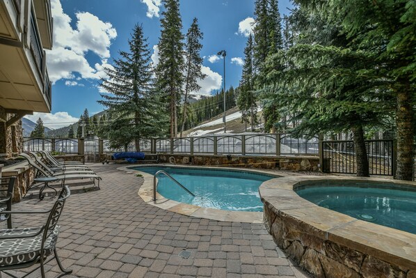 A pool area with lounge chairs and a stone pathway.