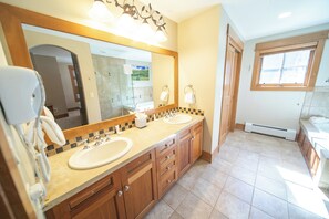 A bathroom with two sinks, a large mirror, and a window. - Lone Eagle 3034 by SummitCove Vacation Lodging (Keystone)
