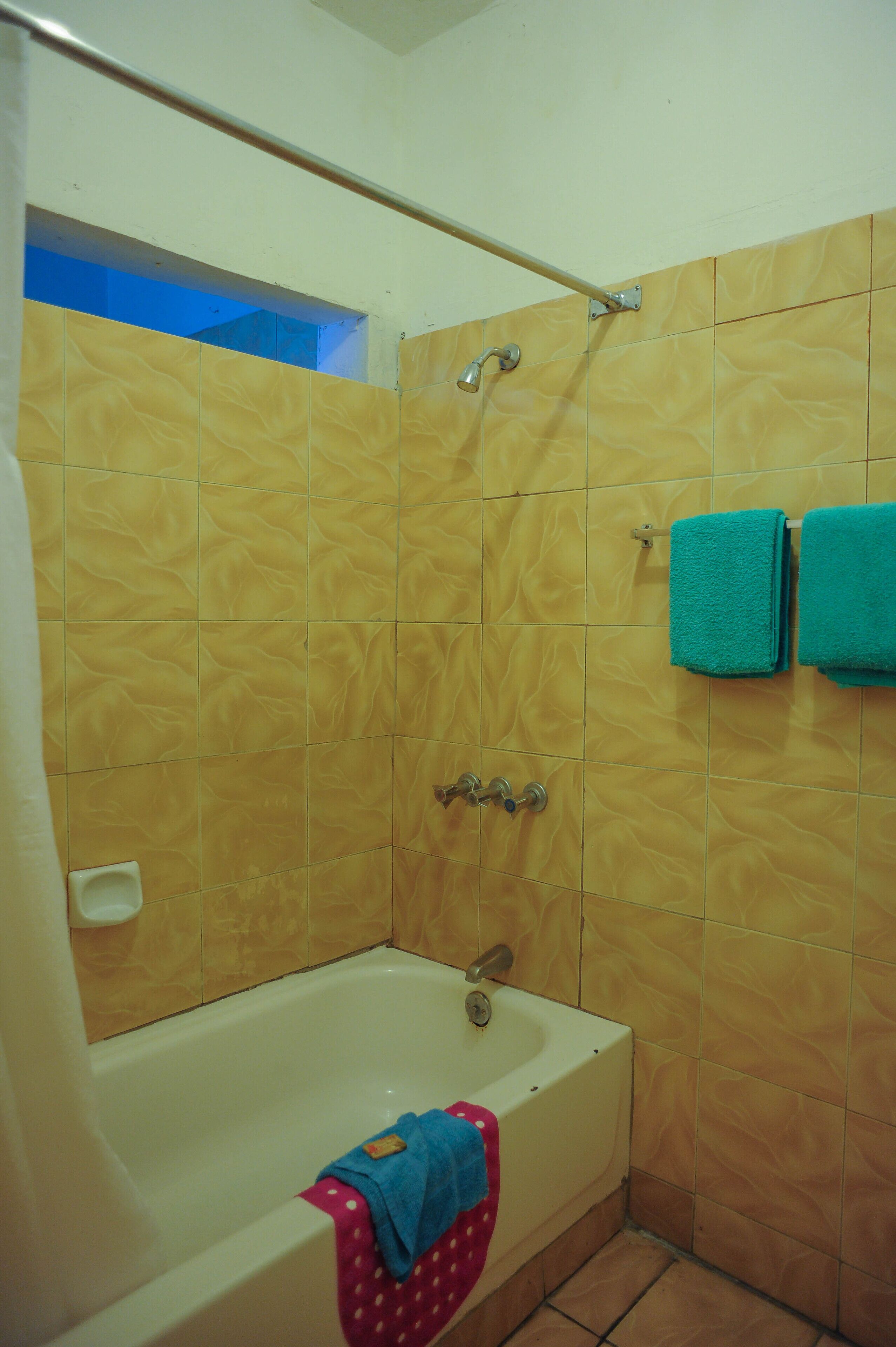 A bathroom with a bathtub, a shower, and tiled walls.