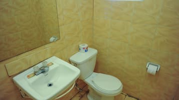 Een badkamer met een wastafel, toilet en een toiletrolhouder aan de muur.
